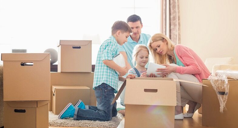 Family unpacking their moving boxes after arriving at their new home