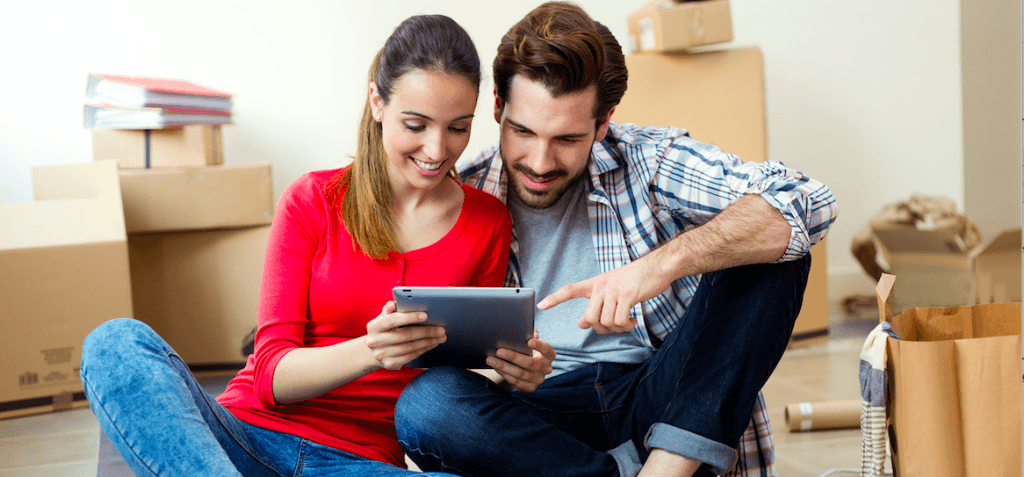 Couple looking at ipad surrounded by boxes