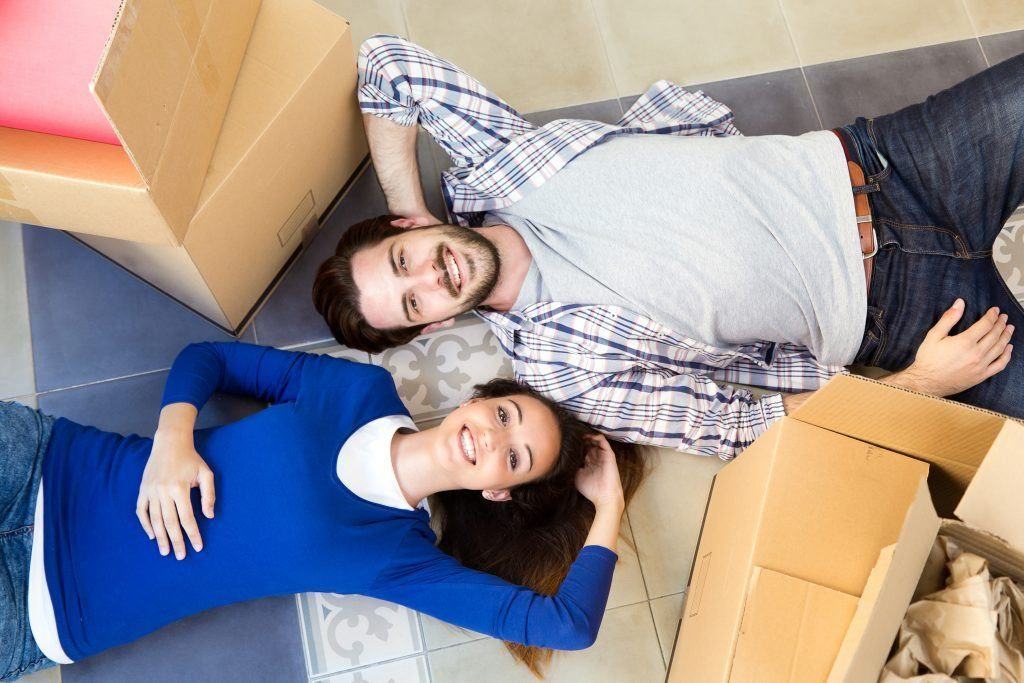 Couple laying down next to moving boxes